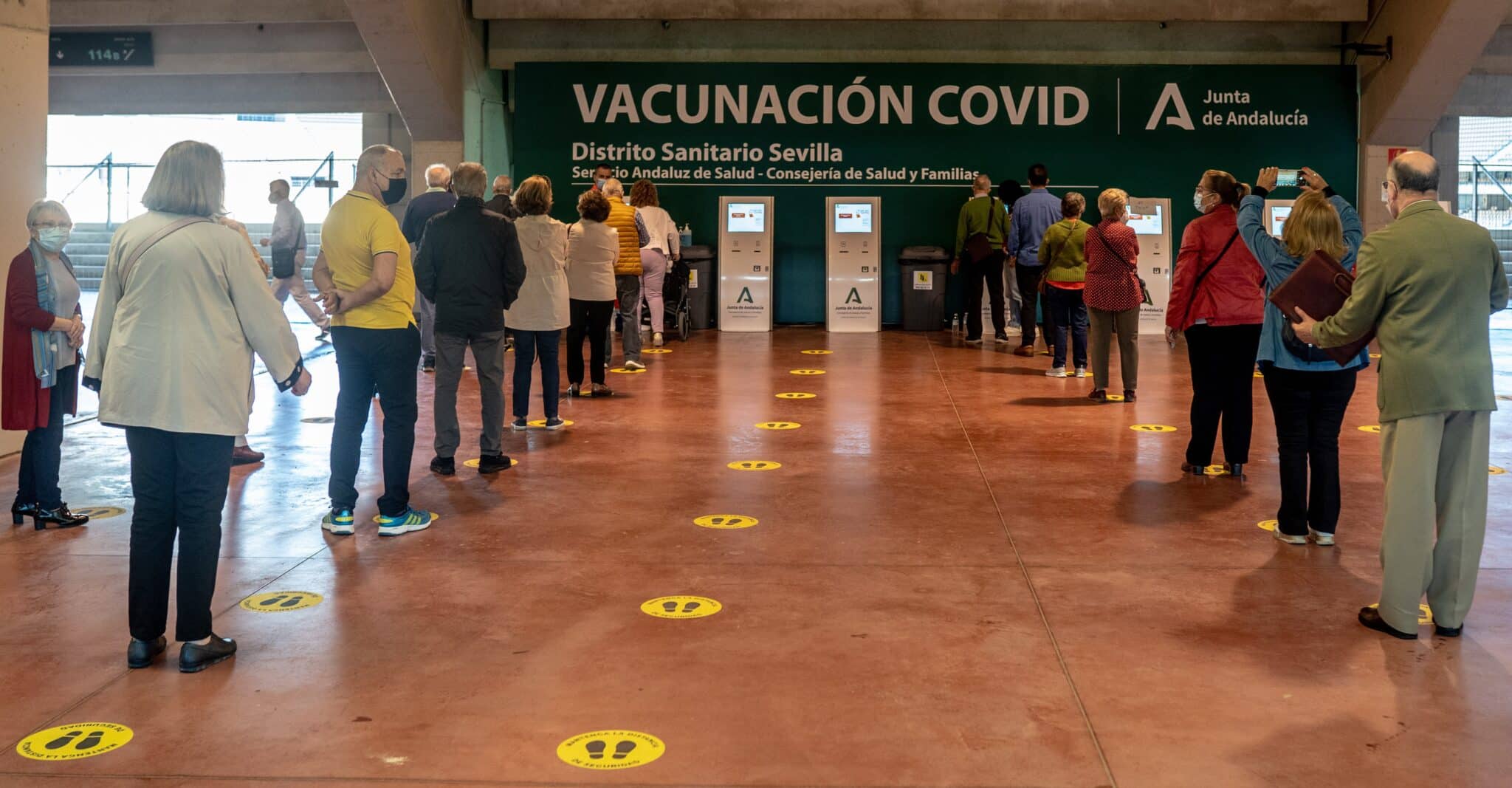 Ciudadanos esperan su turno para recibir la vacuna contra la covid-19 en el estadio sevillano de la Cartuja.