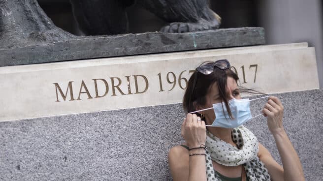 Una mujer se quita la mascarilla en la Puerta del Sol.
