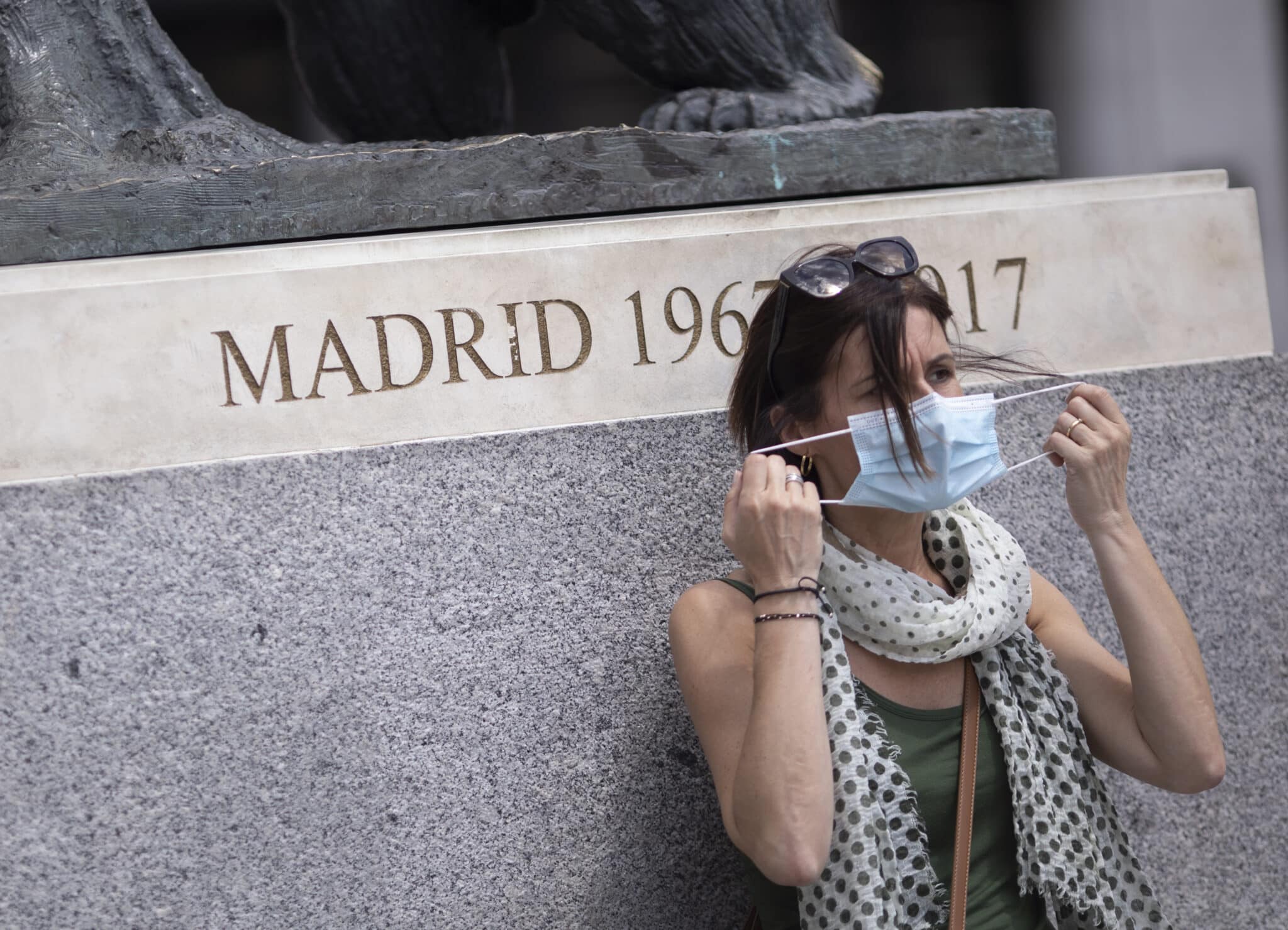 Una mujer se quita la mascarilla en la Puerta del Sol.