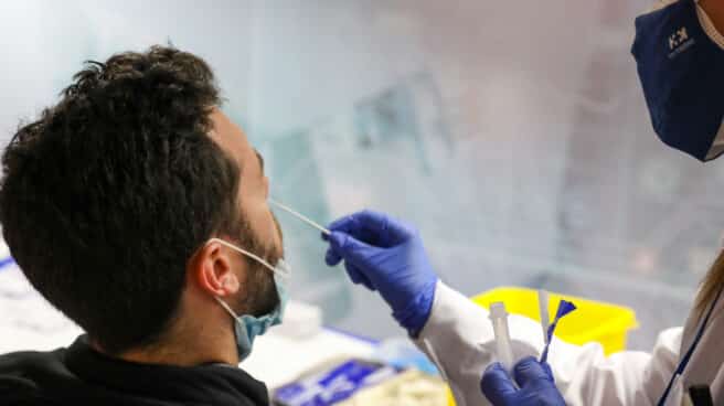 Un sanitario realiza un test de antígenos a un hombre en el intercambiador de Plaza de Castilla