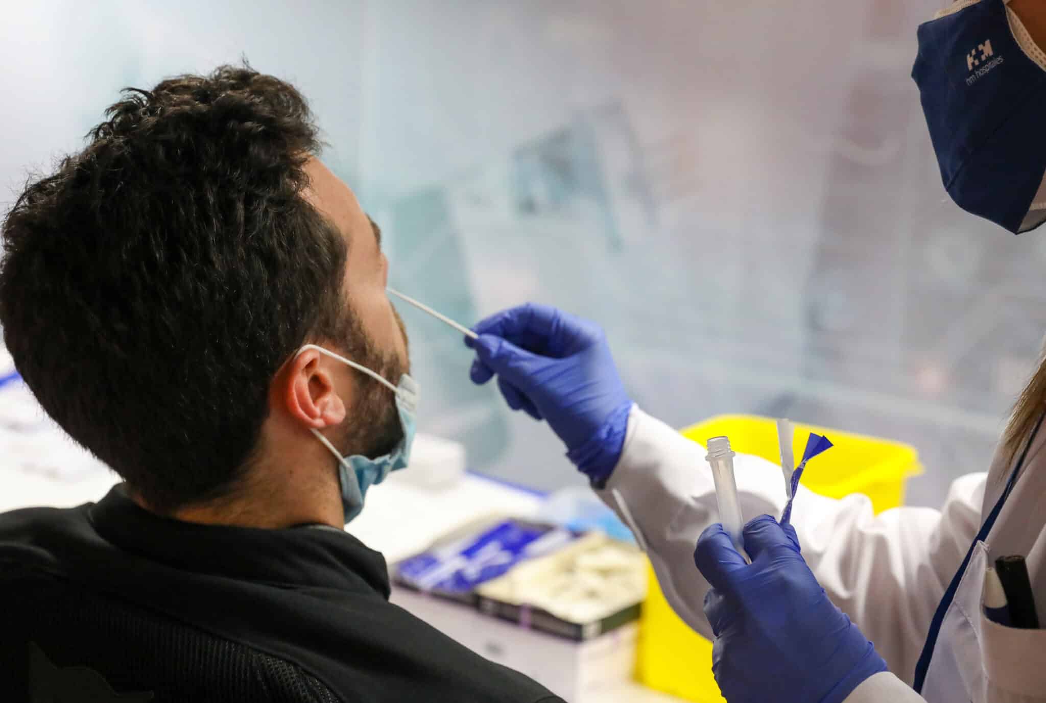 Un sanitario realiza un test de antígenos a un hombre en el intercambiador de Plaza de Castilla