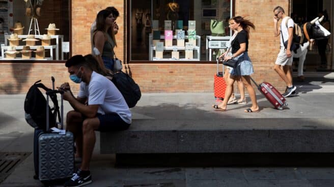comunidad-propietarios-no-puede-prohibir-pisos-turisticos-juez Turistas con equipaje caminando por el centro de Sevilla.