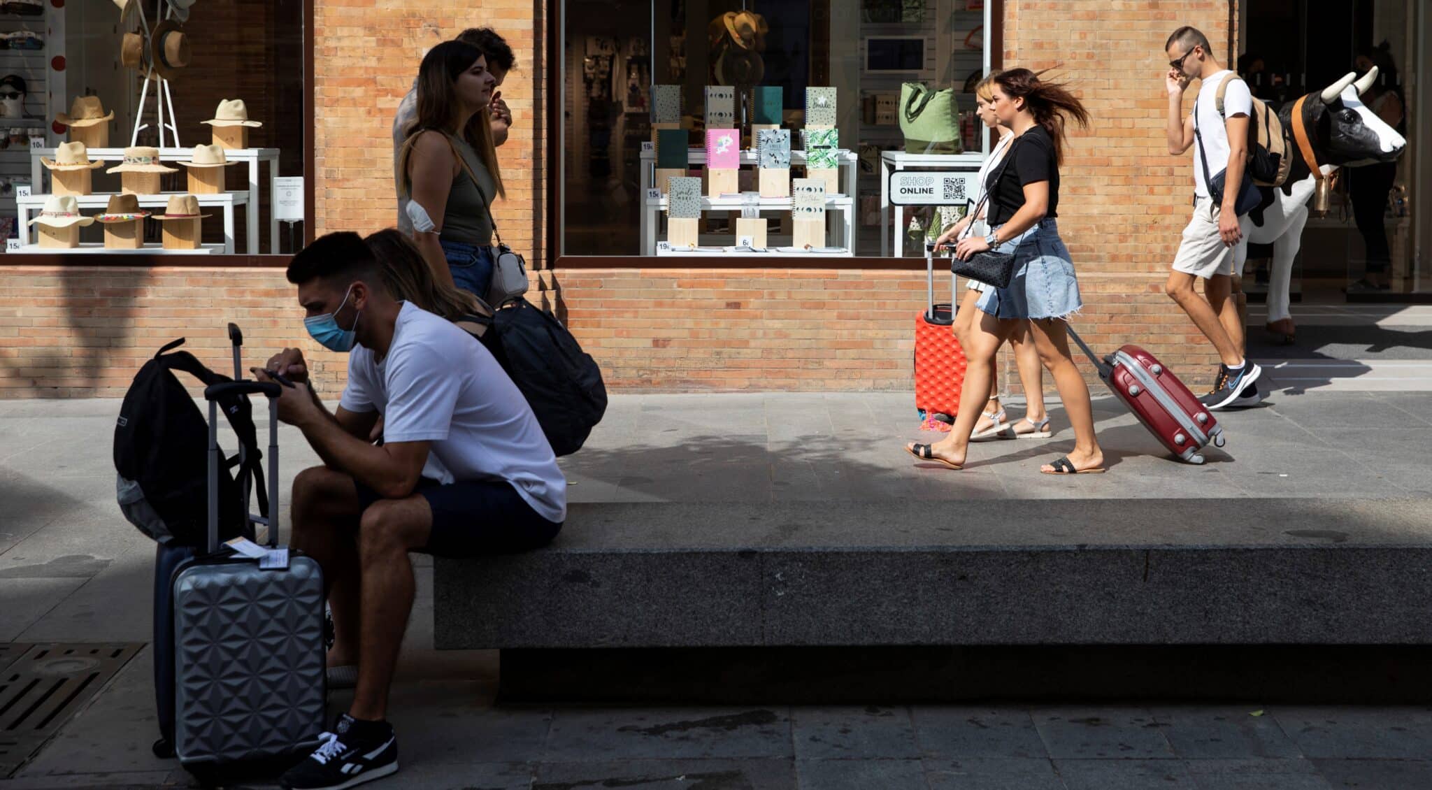 Turistas con equipaje caminando por el centro de Sevilla.