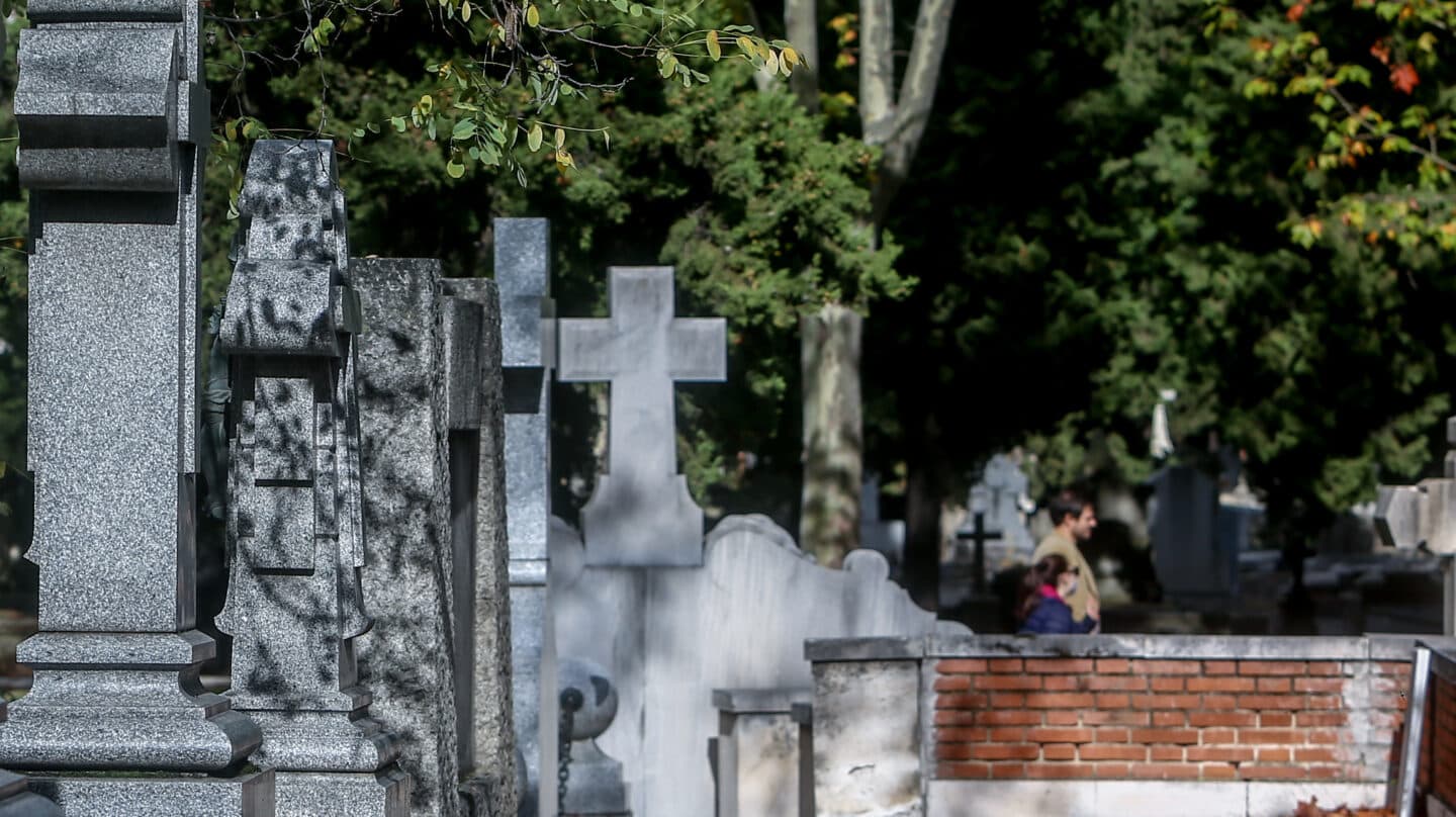 Dos personas andan en el cementerio de La Almudena en Madrid.
