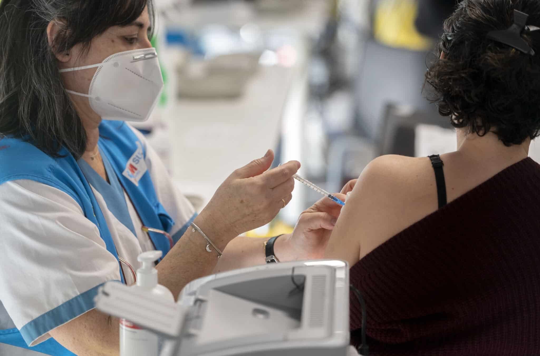 Una mujer recibe la tercera dosis de la vacuna contra el Covid-19, en el WiZink Center