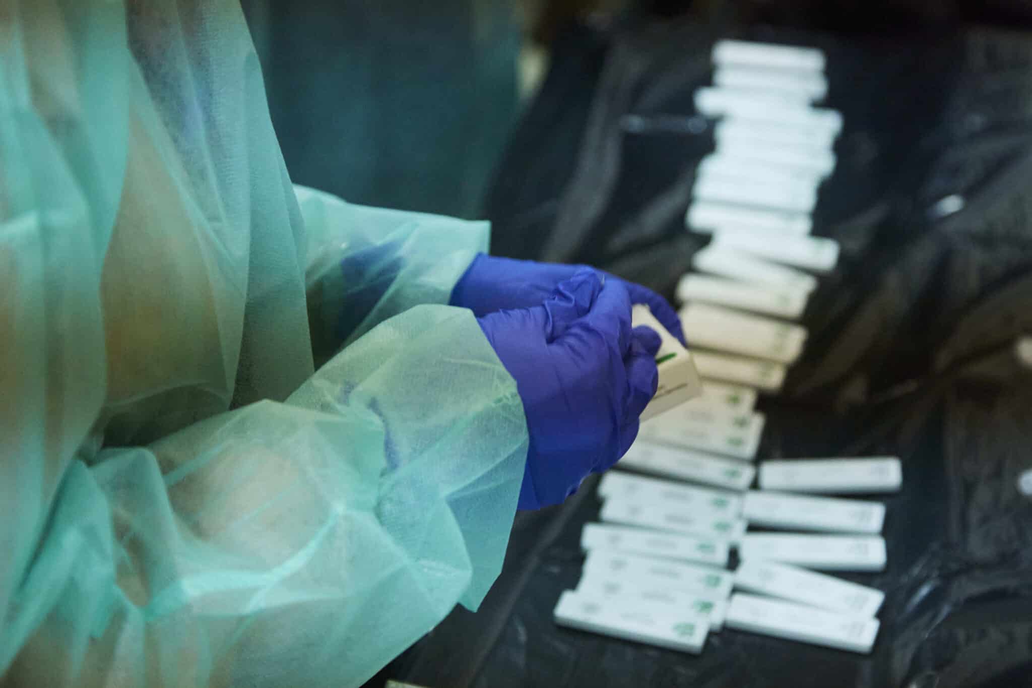 Una enfermera abre un test de antígeno para realizarle la prueba a un costalero durante el primer ensayo de costaleros