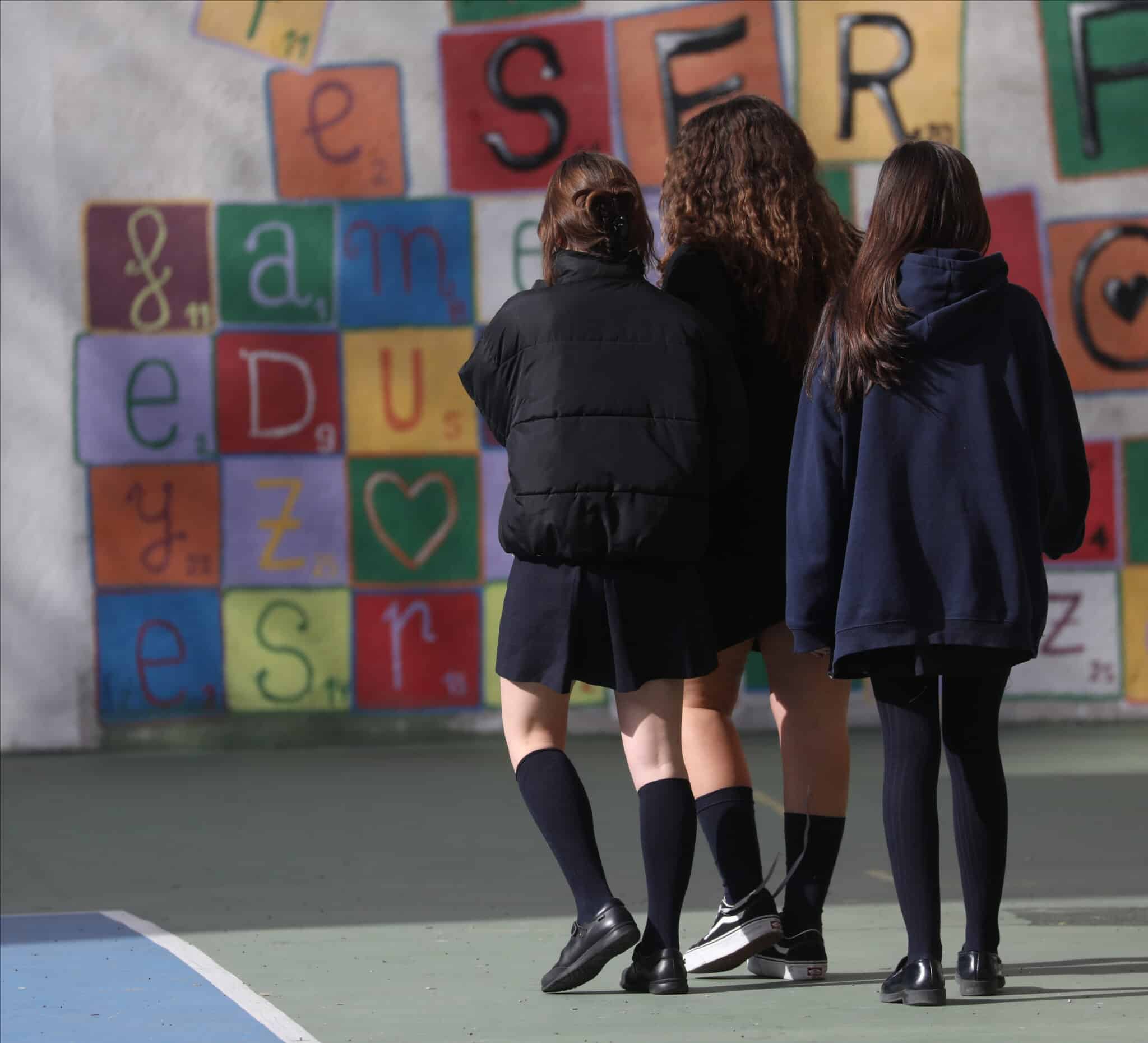 Tres niñas en el patio del colegio.