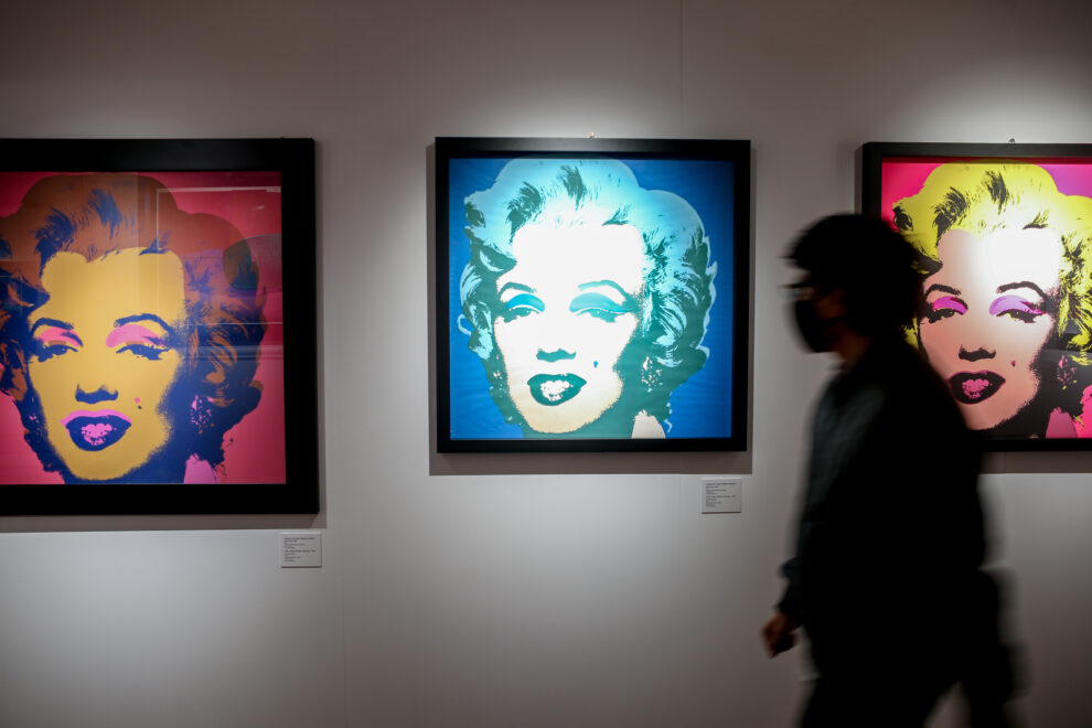 Una persona para por delante de los retratos de Marilyn Monroe,   en la inauguración de la exposición 'ANDY WARHOL SUPER POP'