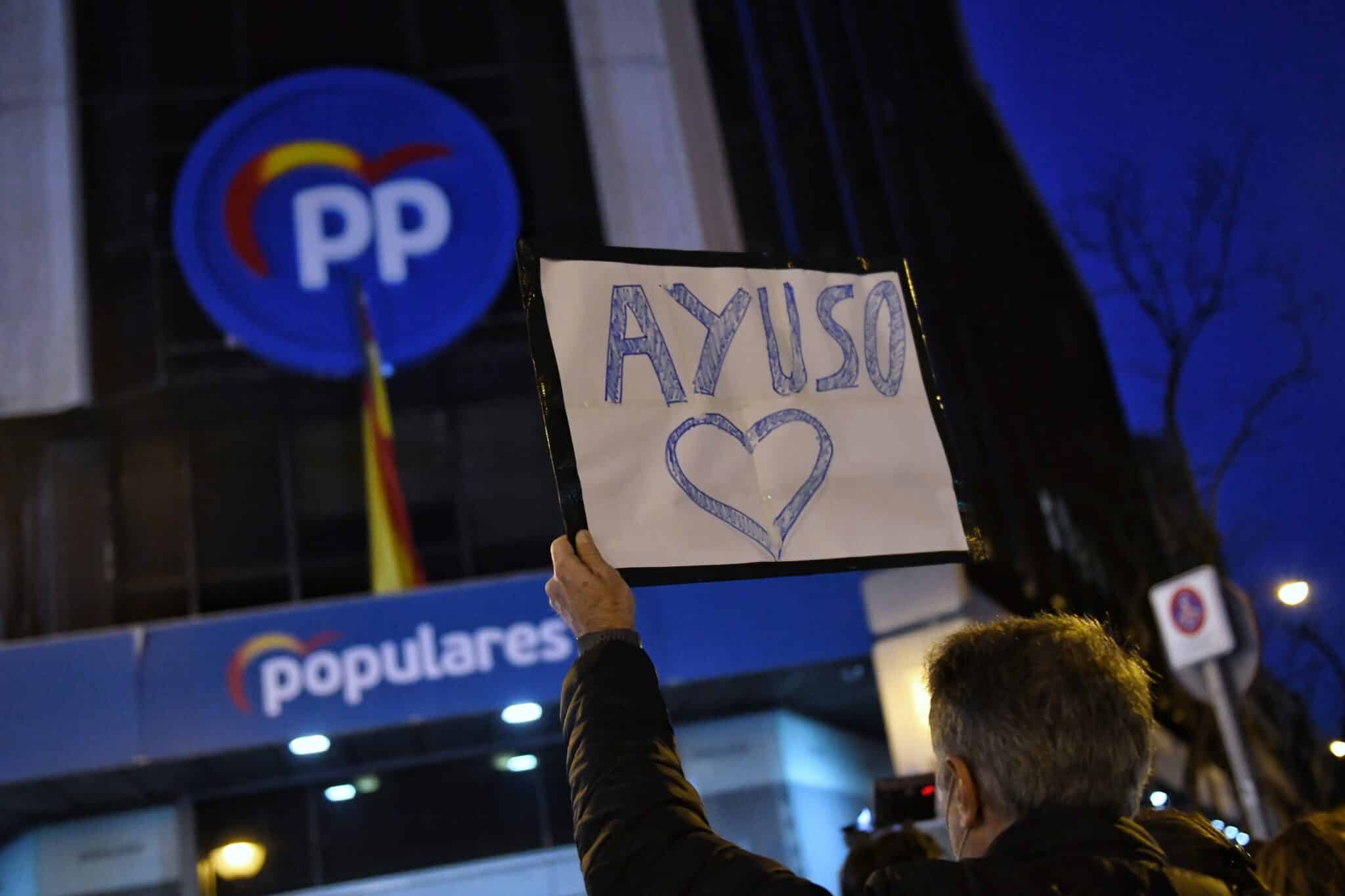 Un hombre sostiene un cartel en el que se lee Ayuso con un corazón, durante una manifestación en apoyo a la presidenta de la Comunidad de Madrid