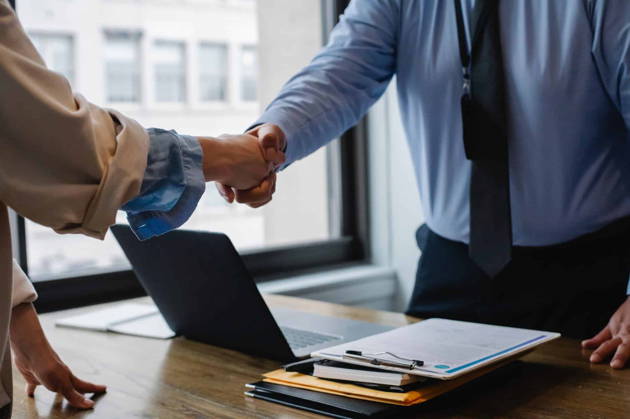 Un trabajador y un empresario se estrechan la mano.