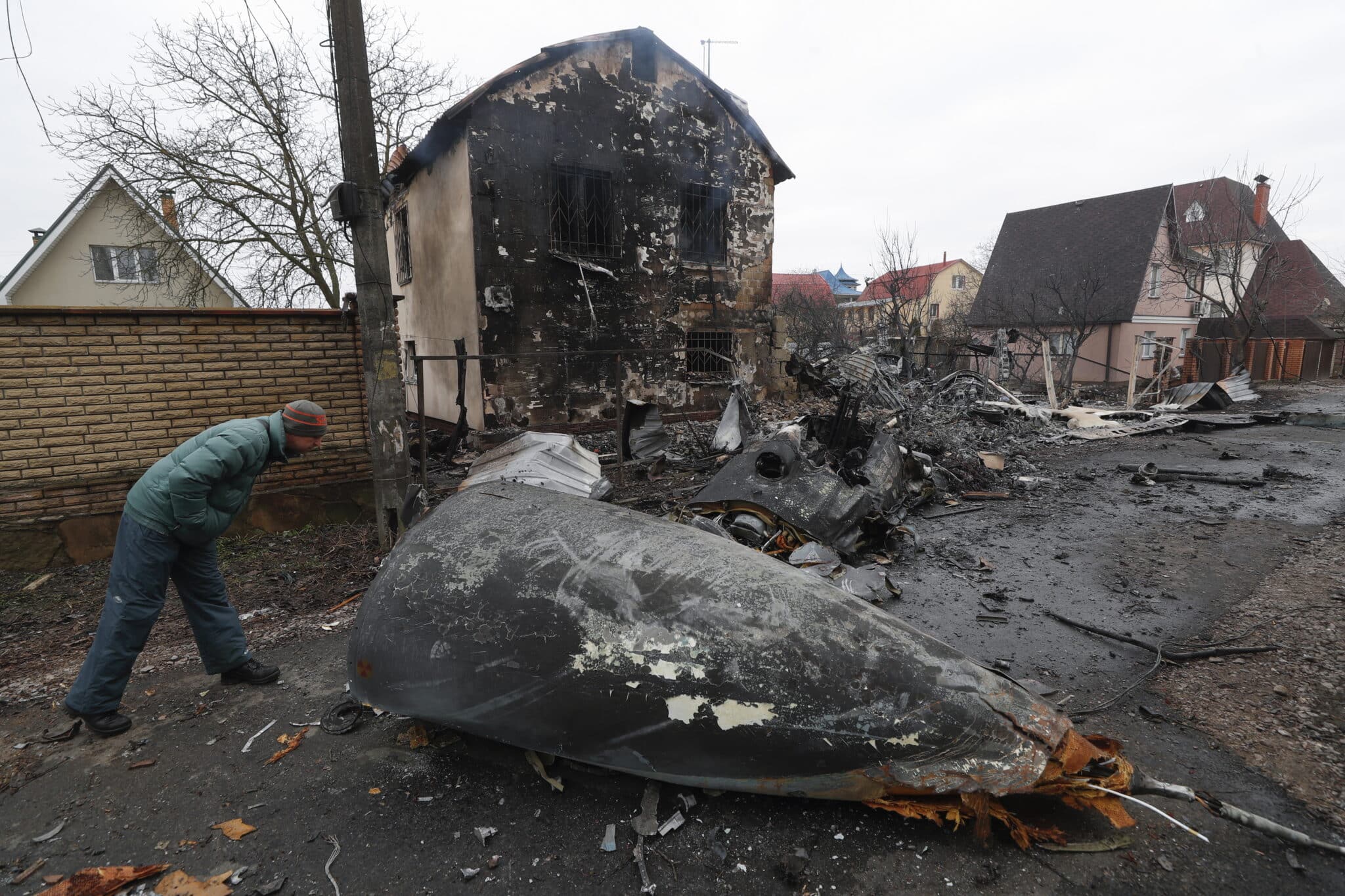 Un hombre mira los restos de un avión militar abatido en Kiev