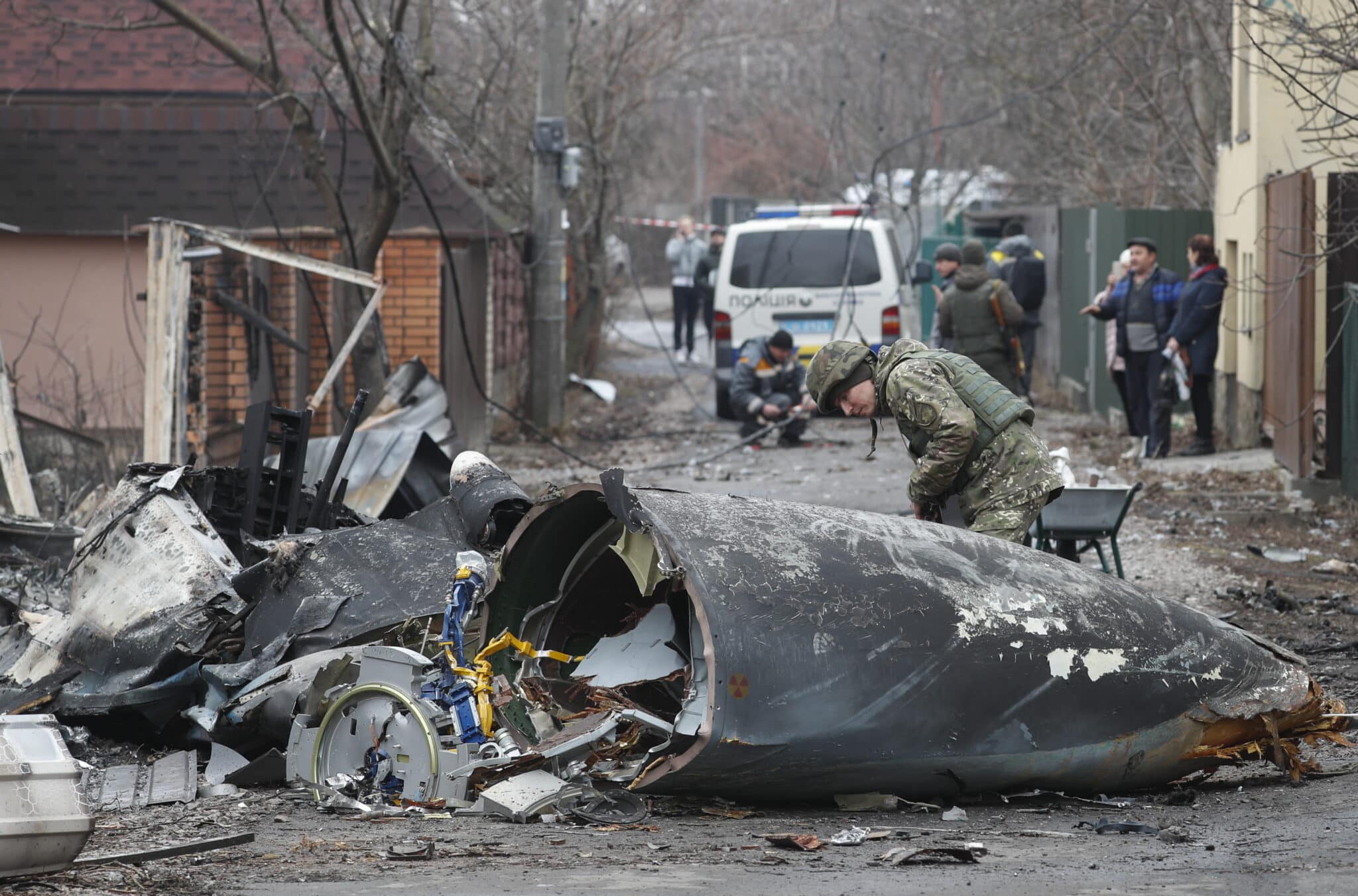 Un soldado observa un avión militar impactado en Kiev