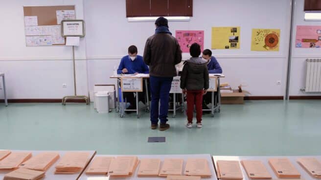 Un hombre, acompañado de su hijo, vota en las elecciones de Castilla y León.