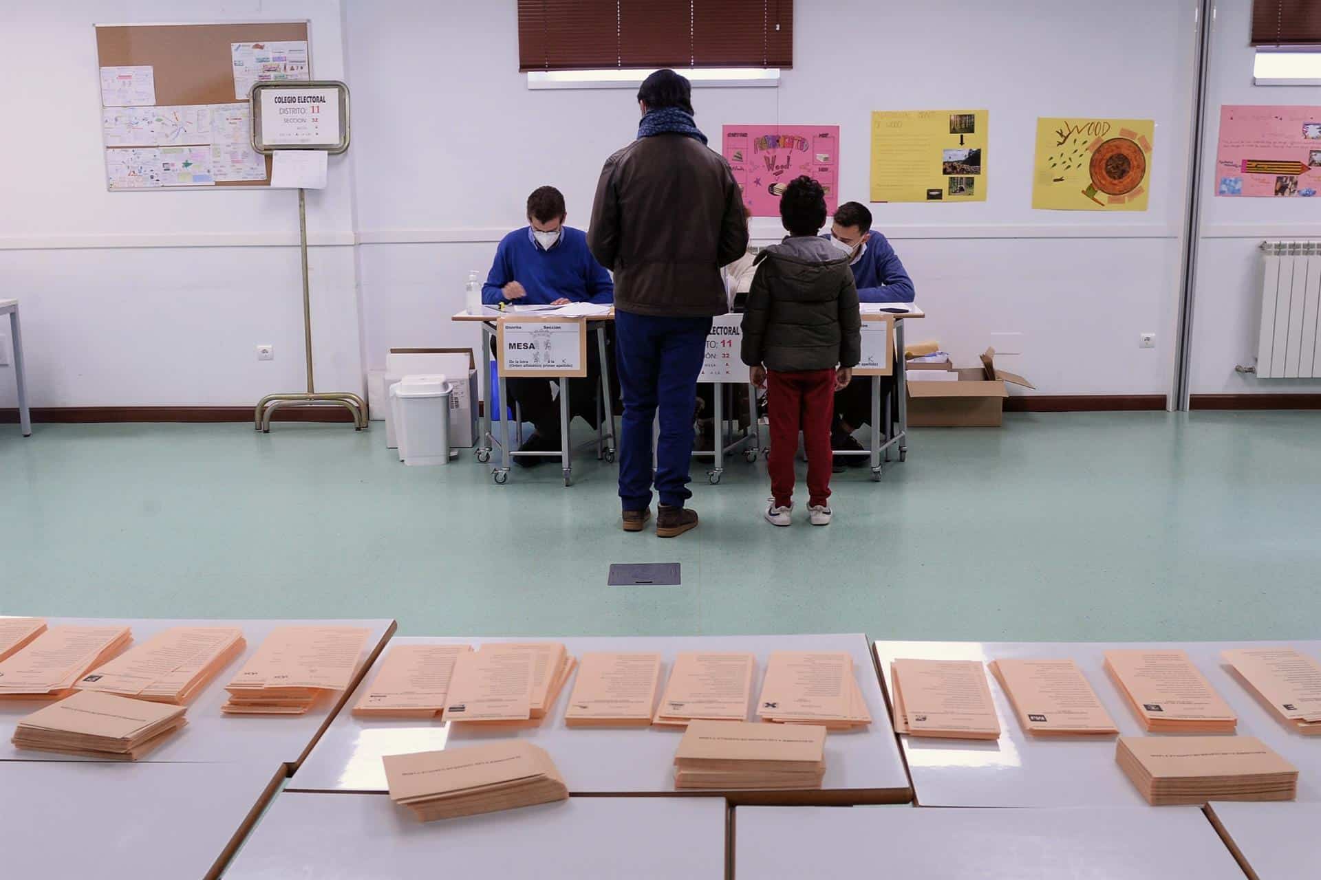 Un hombre, acompañado de su hijo, vota en las elecciones de Castilla y León.