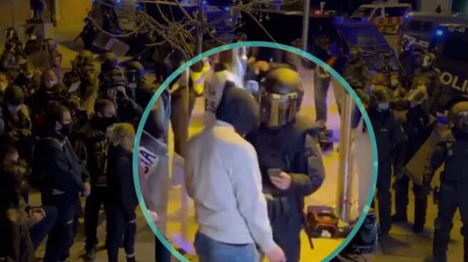proteccion-datos-avala-policia-fotografíe-dni-identificar-persona Un policía identifica a un joven en una manifestación celebrada en Madrid en marzo de 2021 en protesta por el encarcelamiento del rapero Hasel. policía toma una foto a un de DNI de un manifestante