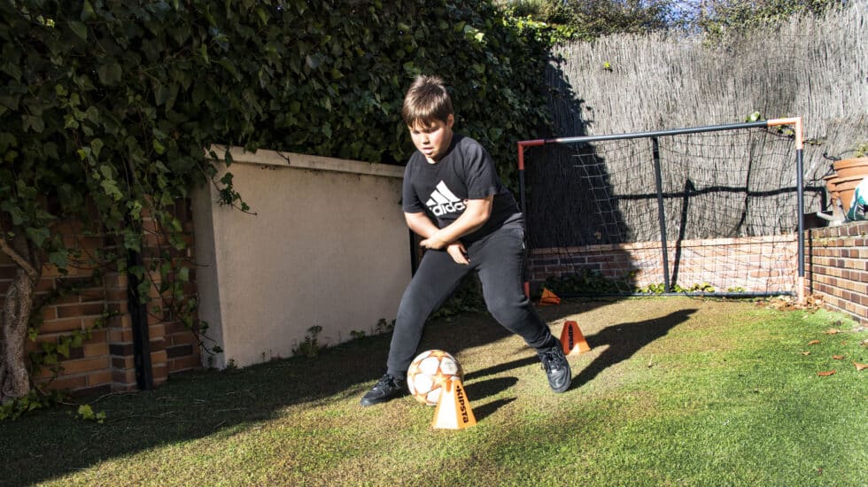 Ignacio, afectado de artrogriposis múltiple congénita, juega al fútbol en su casa.