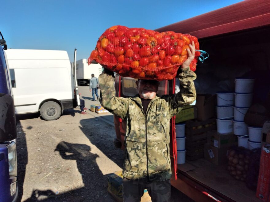 Mariano sostiene un saco de pimientos.