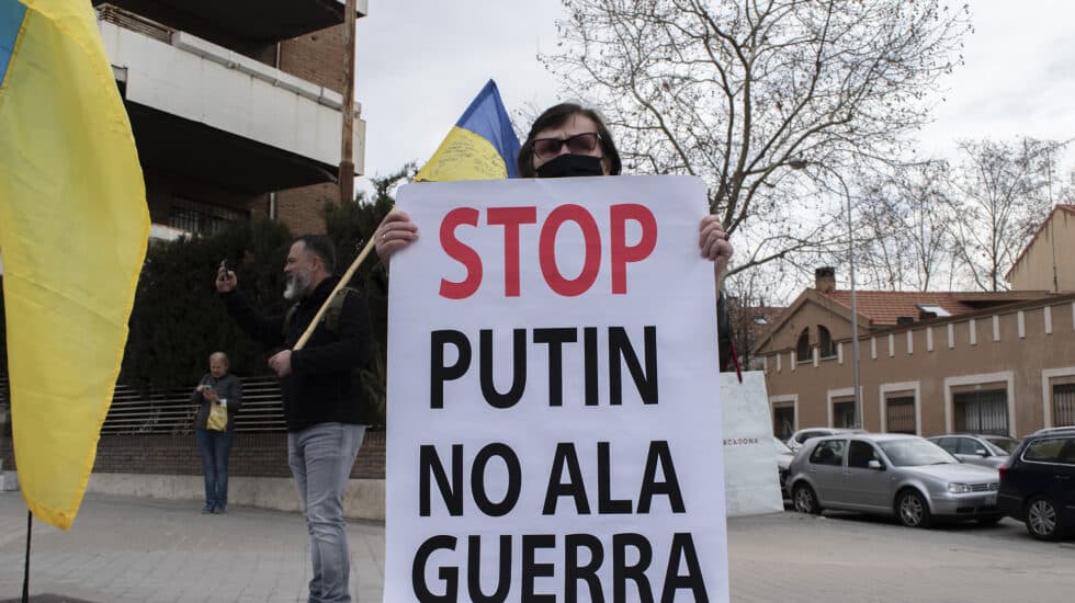 Svitlana, ucraniana residente en España, sostiene un cartel en contra del ataque ruso frente a la embajada rusa en Madrid.