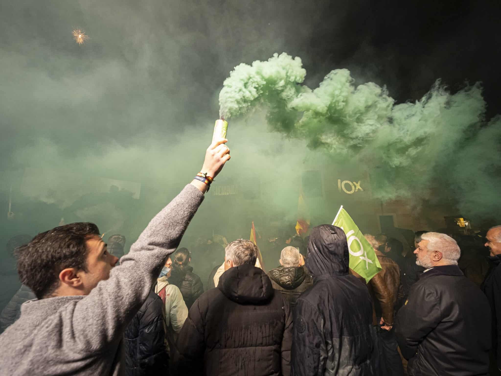 Humo verde y banderas de Vox, durante la valoración de los resultados obtenidos de Vox en los comicios para Castilla y León durante la noche electoral del 13F.