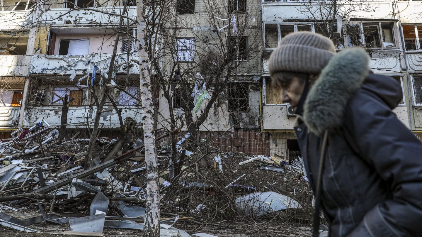 Una mujer pasa junto a los escombros de un edificio dañado por los bombardeos en Kiev.