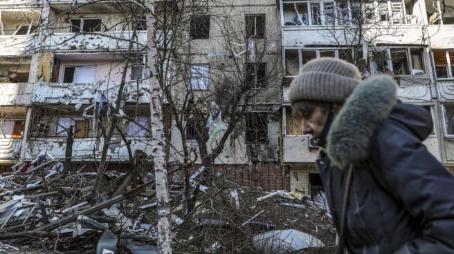 Una mujer pasa junto a los escombros de un edificio dañado por los bombardeos en Kiev.