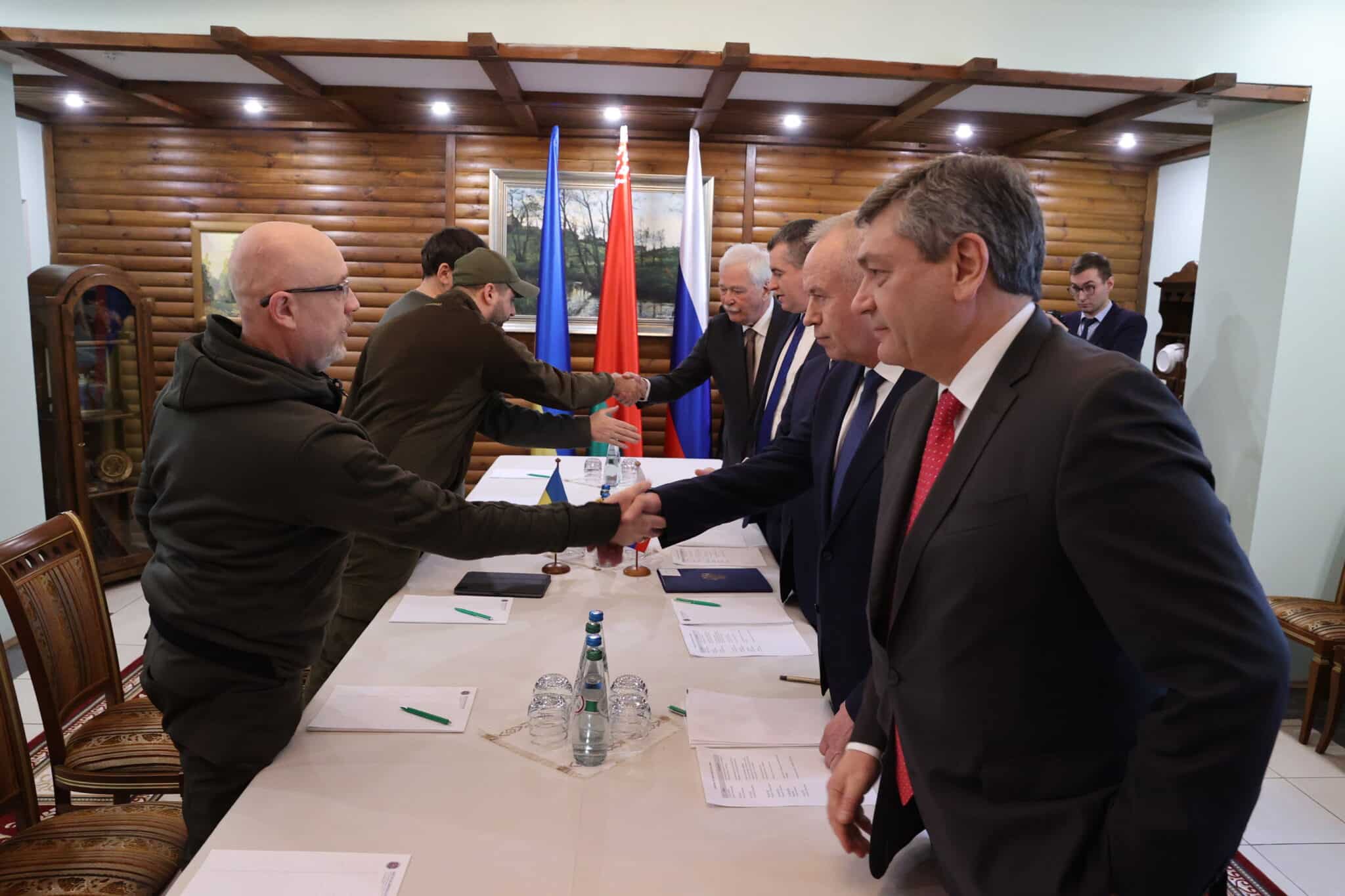 Negociadores rusos y ucranianos se dan la mano en su reunión en Bielorrusia.
