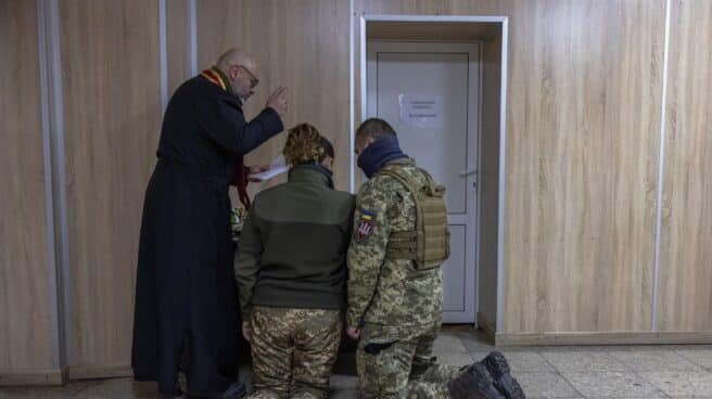Un sacerdote celebra una boda entre dos combatientes ucranianos en la región de Kiev.