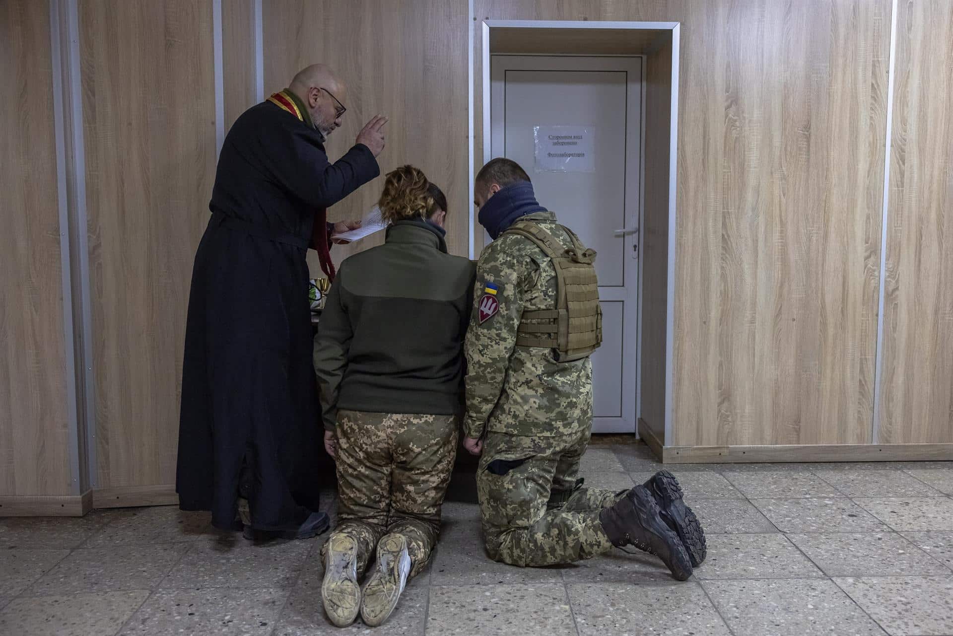 Un sacerdote celebra una boda entre dos combatientes ucranianos en la región de Kiev.