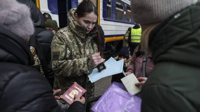 Una soldado ucraniana firma pasaportes para evacuar civiles.