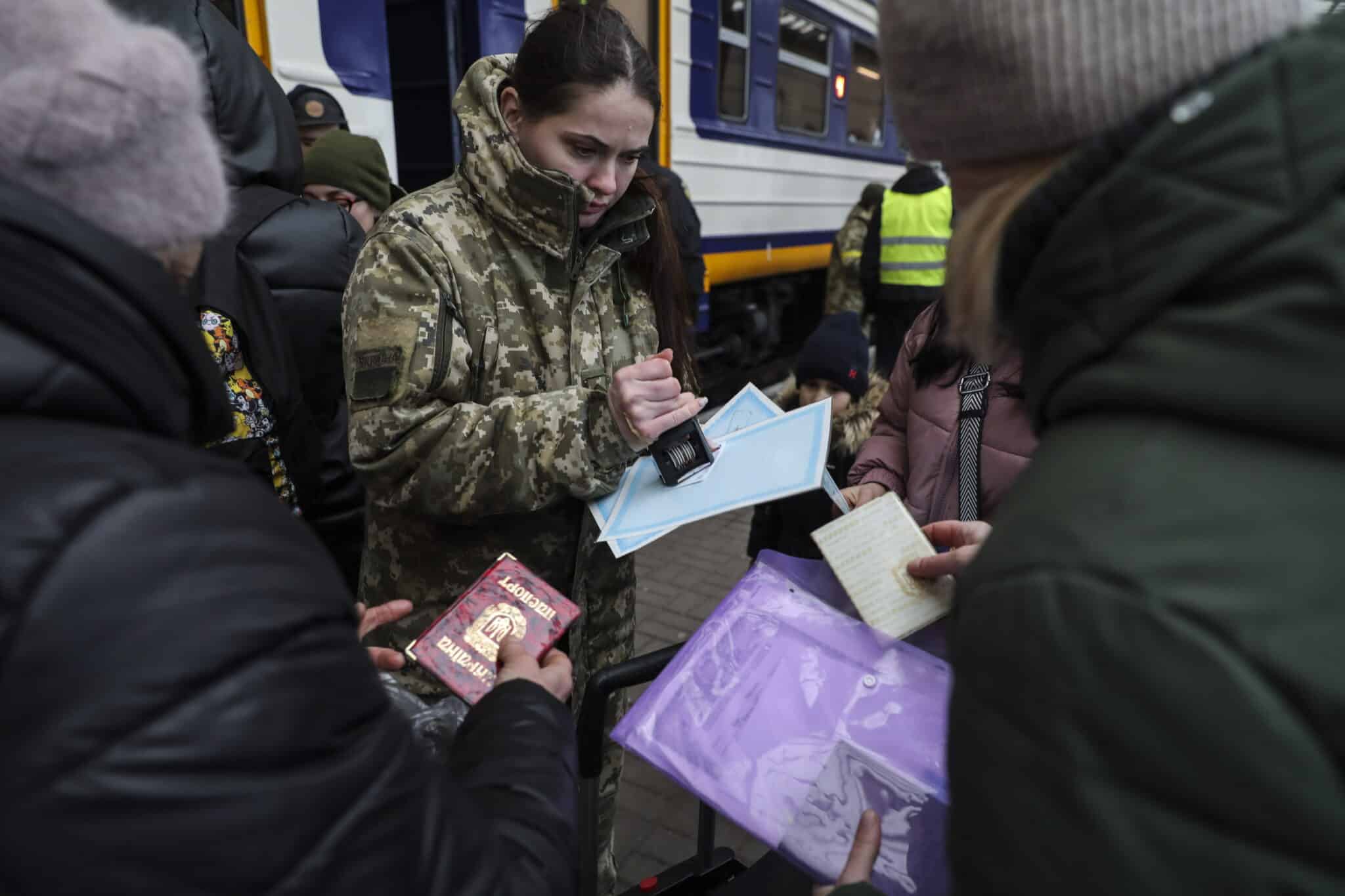 Una soldado ucraniana firma pasaportes para evacuar civiles.