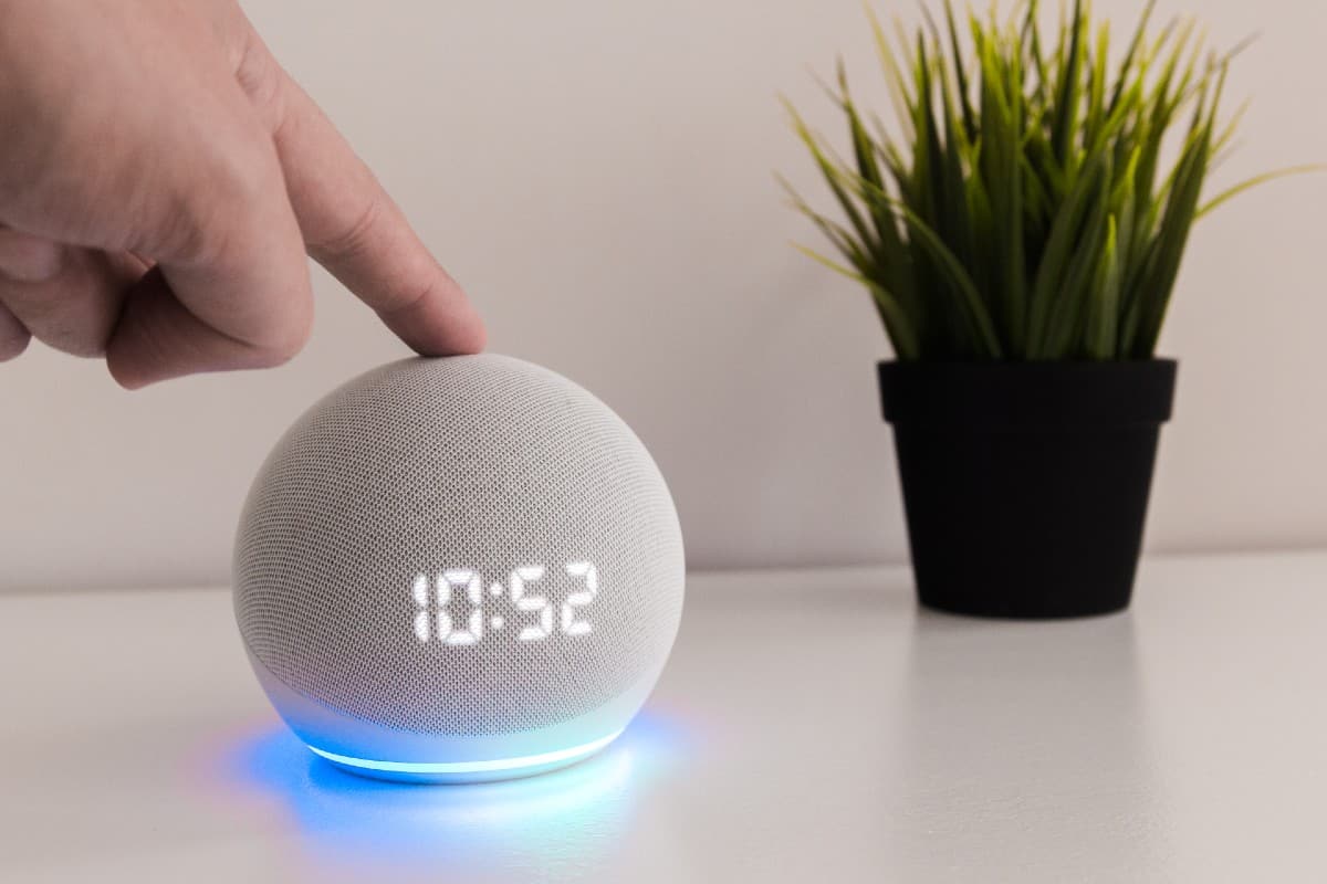 Persona pulsando un altavoz inteligente Echo Dot de 4ª generación