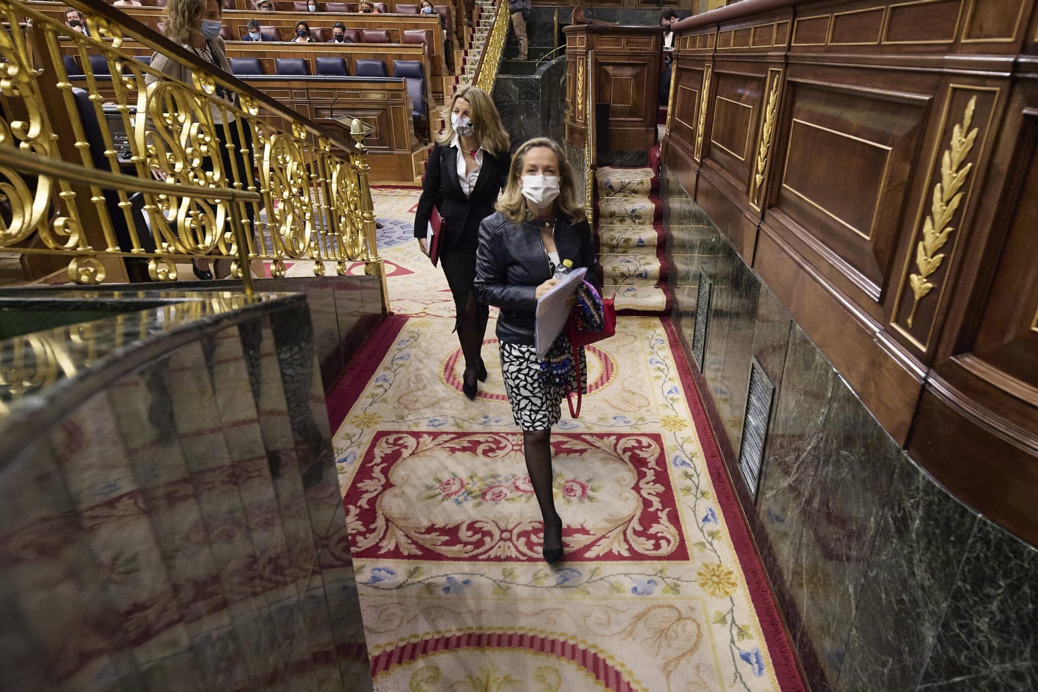 La vicepresidenta segunda y ministra de Trabajo, Yolanda Díaz (detrás) y la vicepresidenta primera y ministra de Asuntos Económicos, Nadia Calviño, en el Congreso de los Diputados.