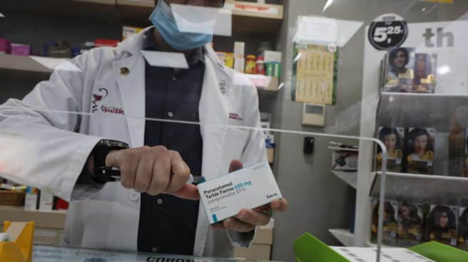 Un farmacéutico dispensa una caja de paracetamol.