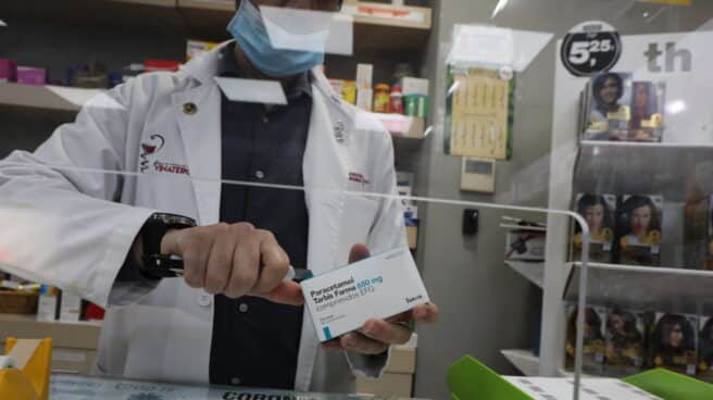 Un farmacéutico dispensa una caja de paracetamol. Un farmacéutico dispensa una caja de paracetamol.