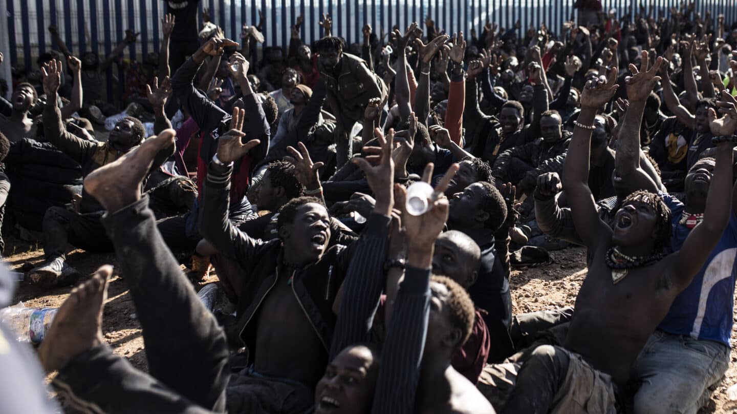 Unos 500 migrantes hacen el signo de la victoria tras saltar el pasado miércoles la valla de Melilla.