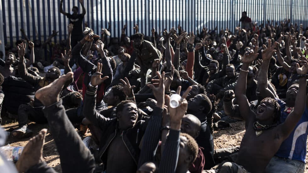 Unos 500 migrantes hacen el signo de la victoria tras saltar el pasado miércoles la valla de Melilla.