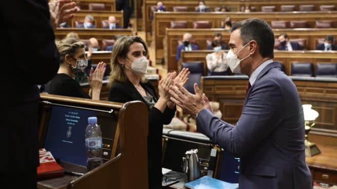 Las ministras Yolanda Díaz y Teresa Ribera junto al presidente Pedro Sánchez aplauden en el hemiciclo.