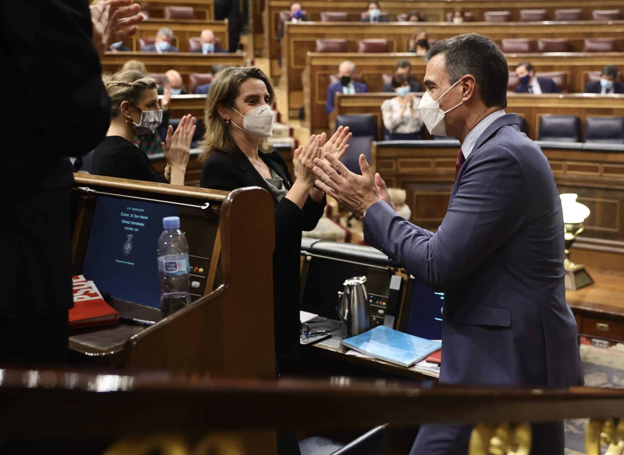 Las ministras Yolanda Díaz y Teresa Ribera junto al presidente Pedro Sánchez aplauden en el hemiciclo.