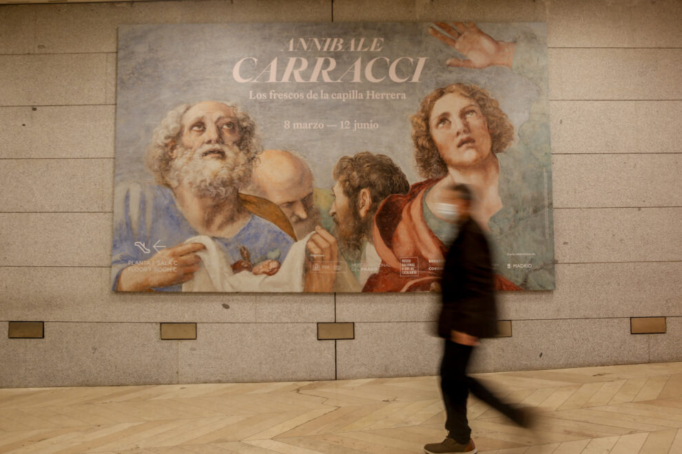 Una persona pasa por delante del cartel de presentación de la exposición ‘Annibale Carracci. Los frescos de la capilla Herrera’, en el Museo Nacional del Prado