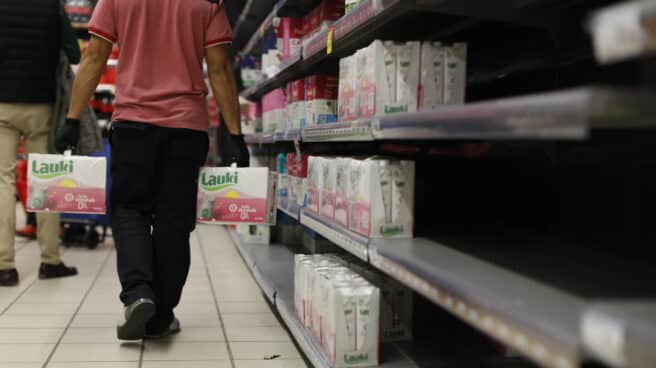 Un reponedor con cajas de leche en un supermercado de Madrid.