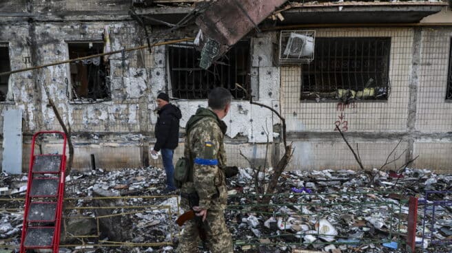 Un soldado pasa por delante de un edificio dañado por el bombardeo en Kiev
