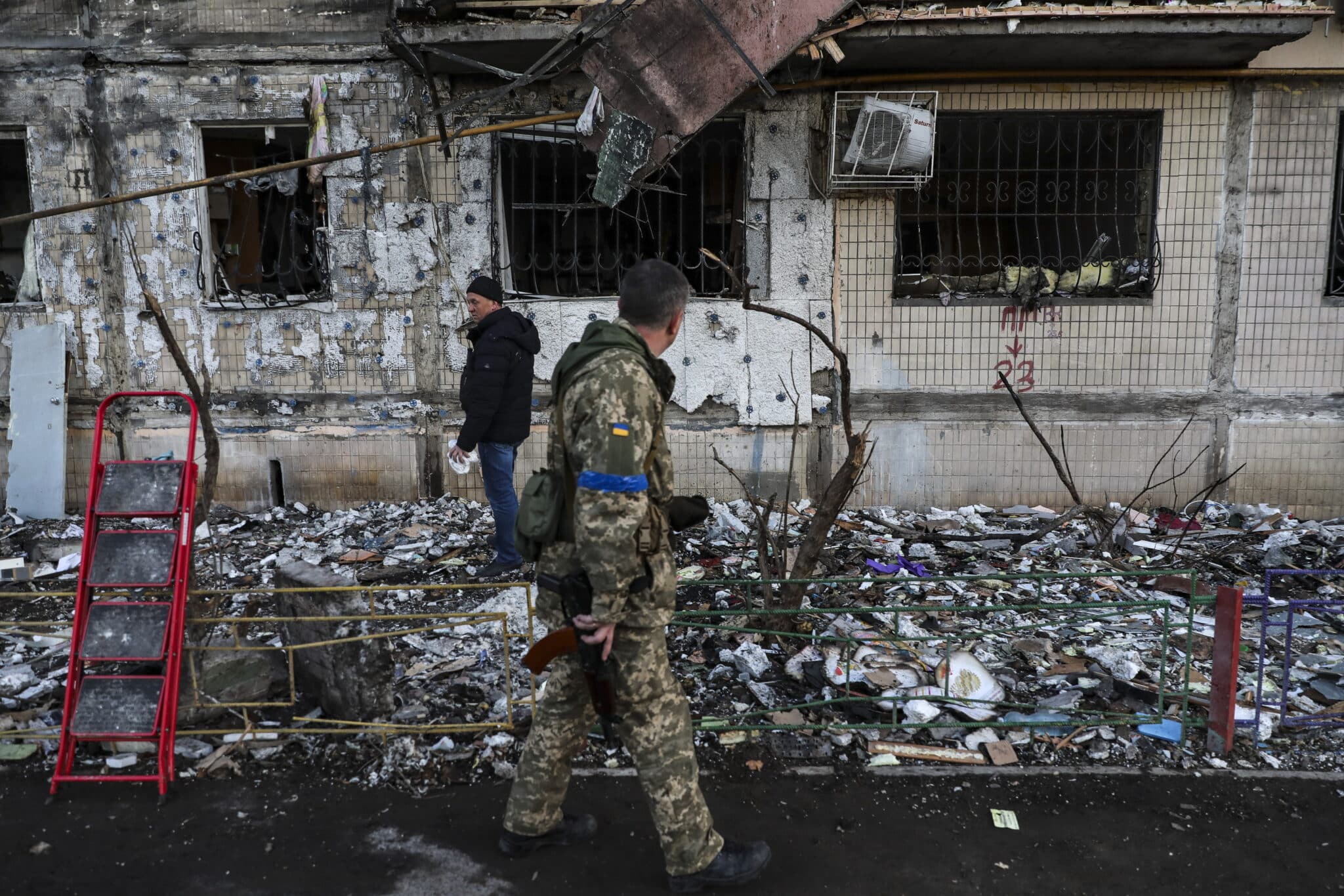 Un soldado pasa por delante de un edificio dañado por el bombardeo en Kiev