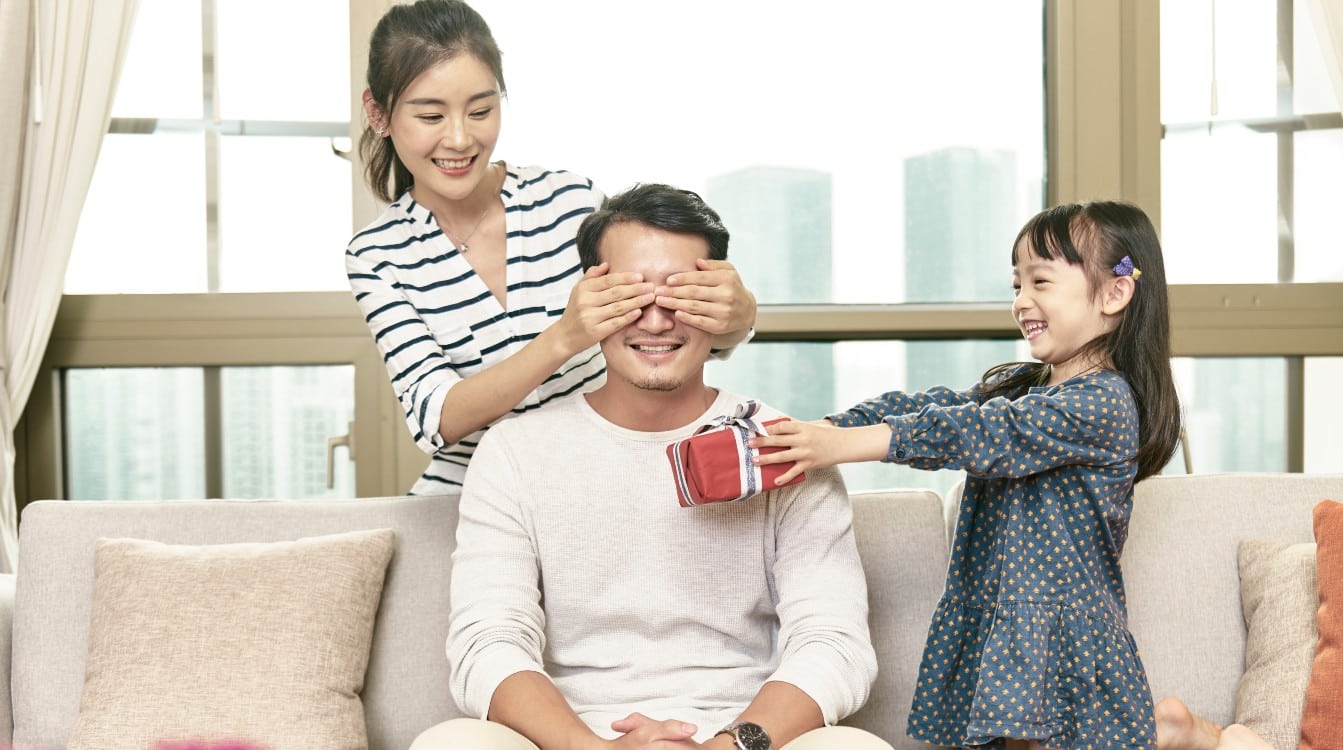 Niñas sorprendiendo a su padre con un regalo por el Día del Padre