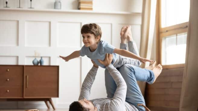 Los regalos más originales personificados para el día del padre Hombre tumbado levantando a un nilño con los brazos extendidos