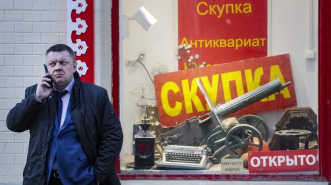 Hombre ruso habla por teléfono frente a una tienda rusa en Moscú
