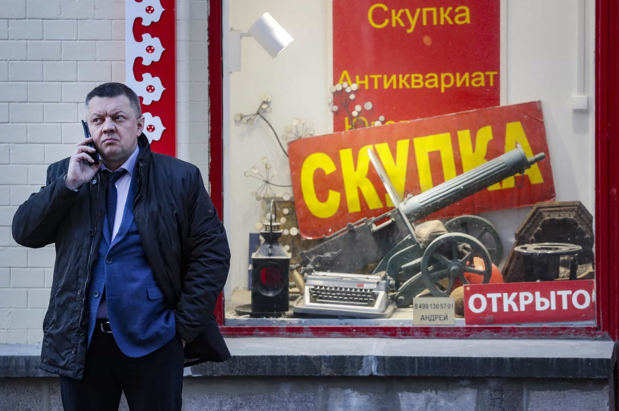 Hombre ruso habla por teléfono frente a una tienda rusa en Moscú