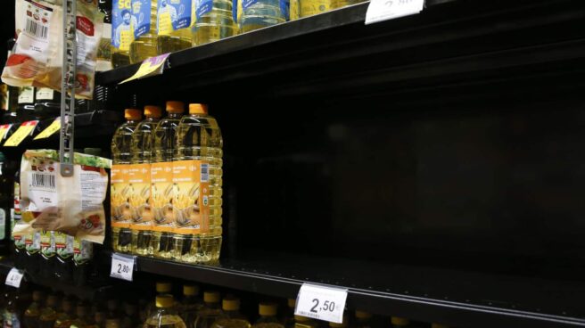 Un expositor casi vacío de botellas de aceite de girasol en un supermercado. Un expositor casi vacío de botellas de aceite de girasol en un supermercado.
