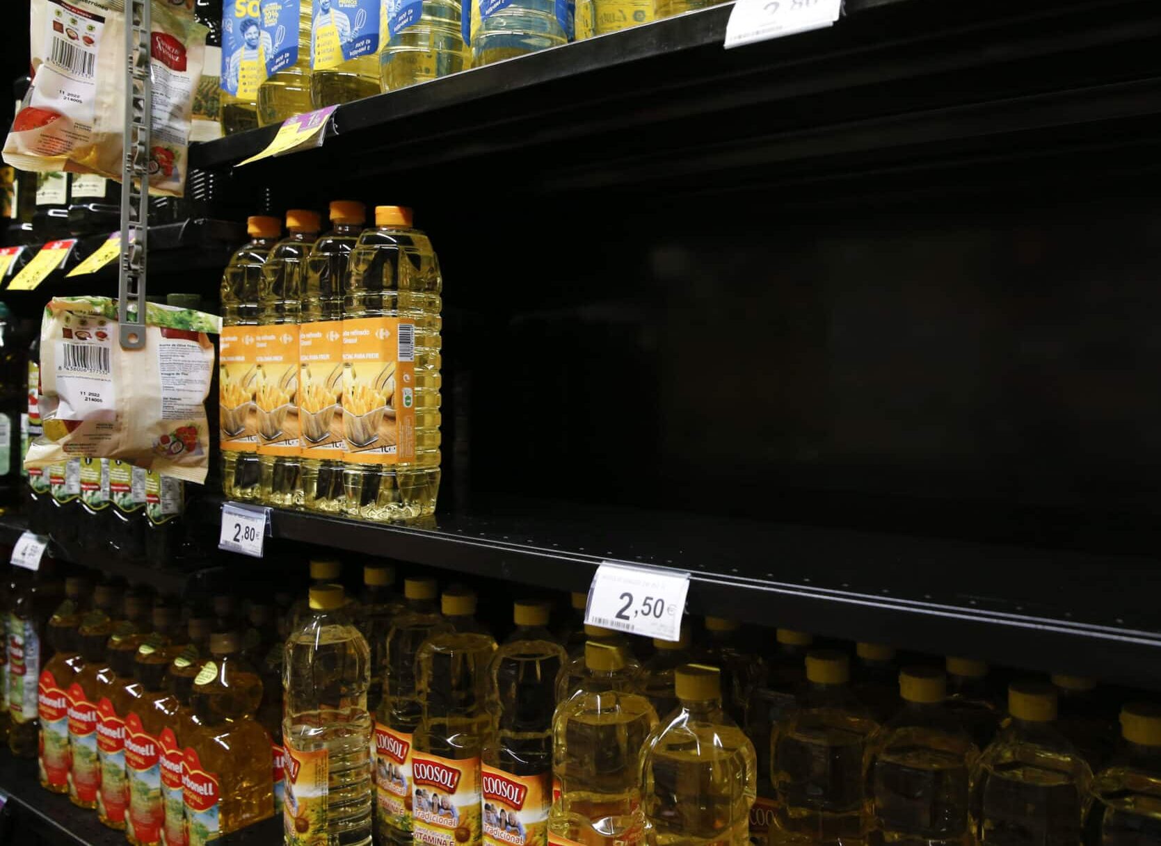 Un expositor casi vacío de botellas de aceite de girasol en un supermercado.