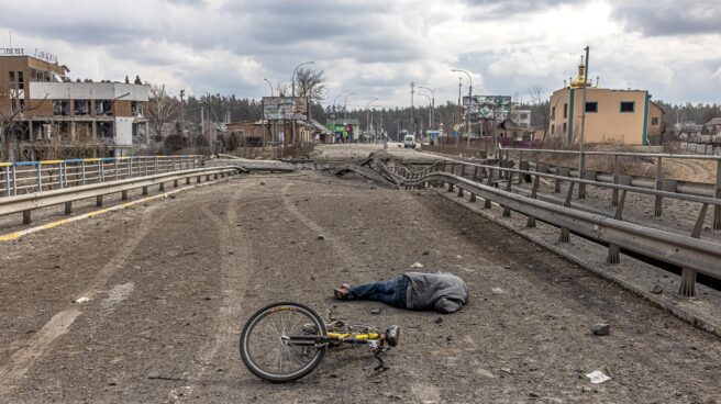 Un hombre yace muerto junto a su bicicleta junto a un puente destruido en Irpin, cerca de Kiev.