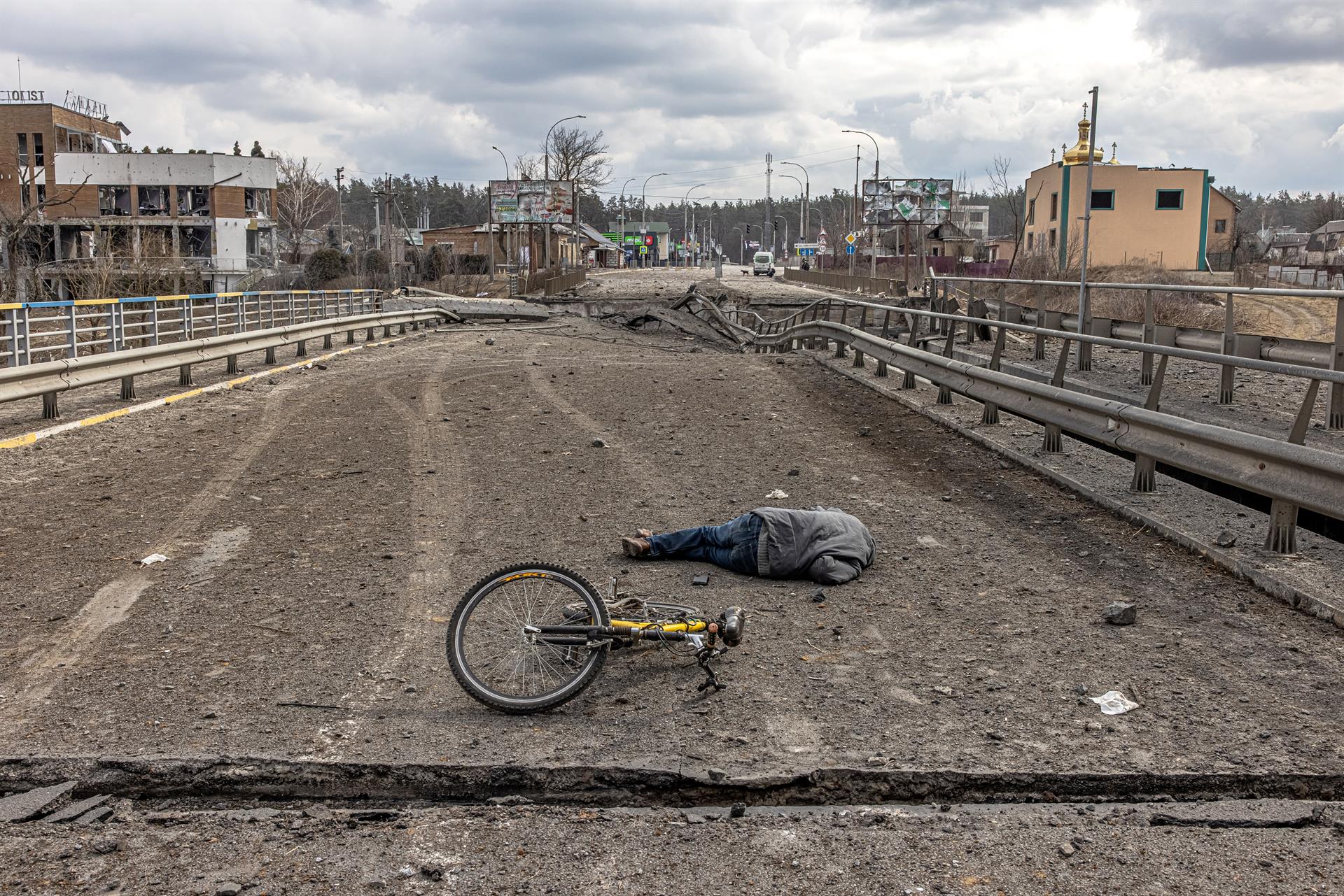 Un hombre yace muerto junto a su bicicleta junto a un puente destruido en Irpin, cerca de Kiev.